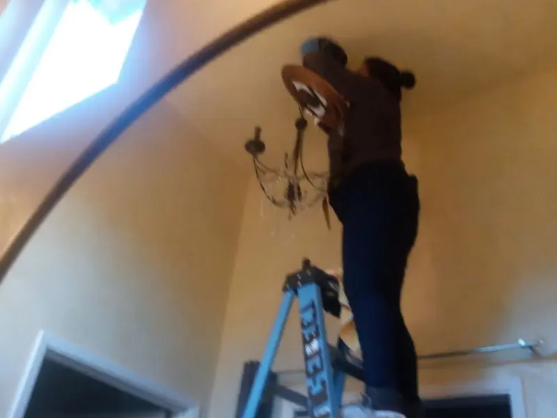 Electrician installing a chandelier in a Omak residence
